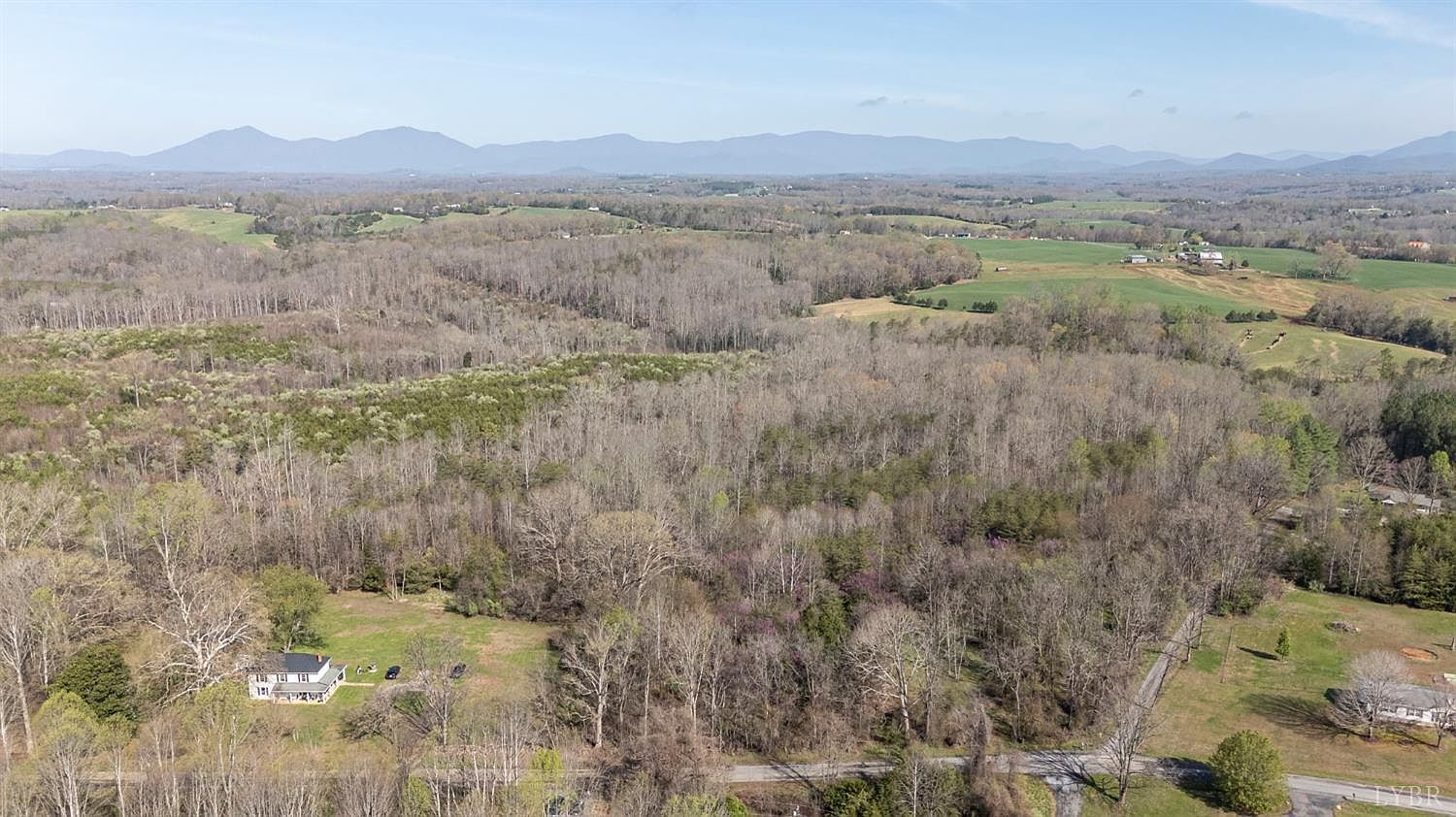 Aerial view over the Goggin Ford Estates wooded homesites with the Blue Ridge Mountains beyond